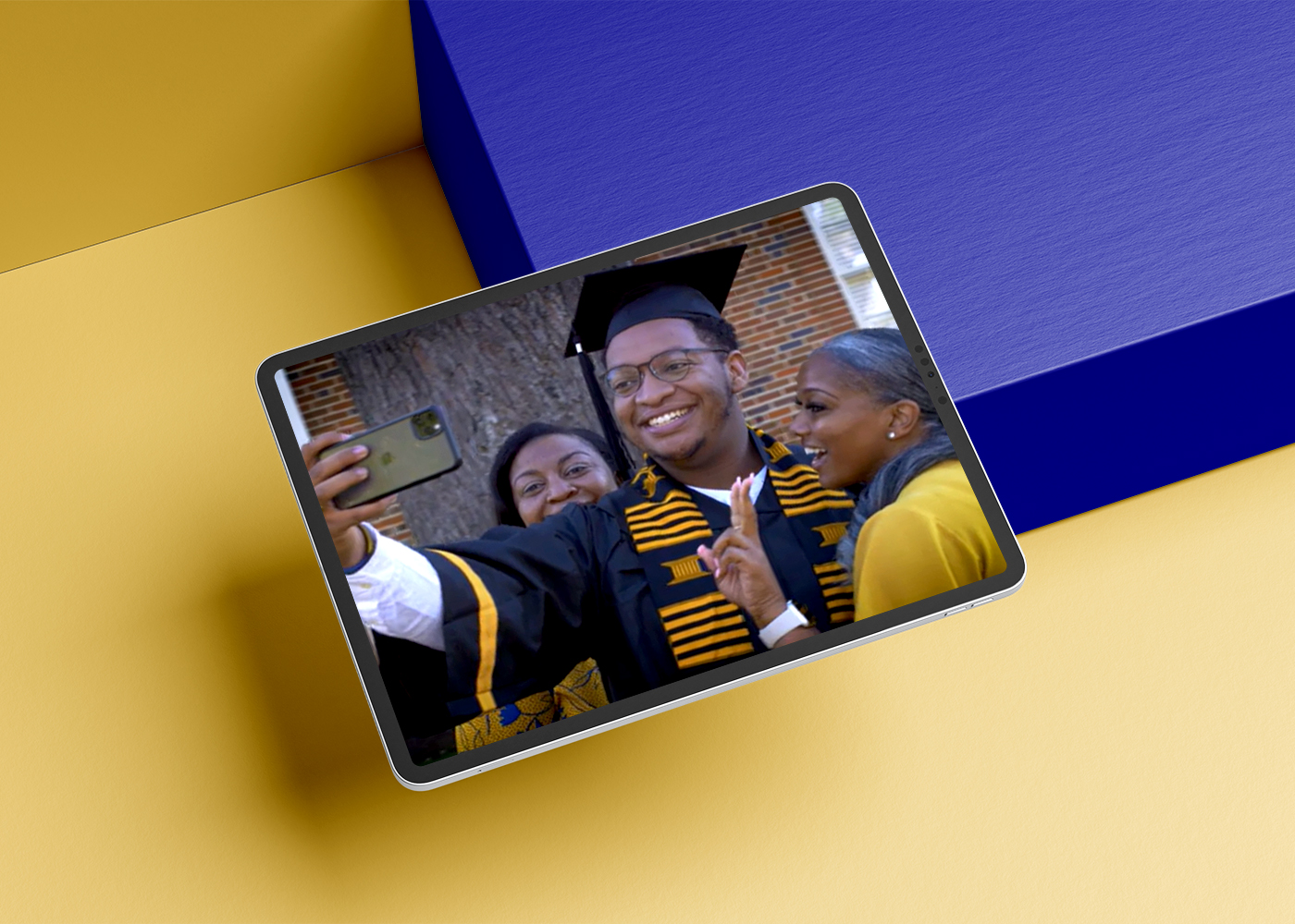 Tablet displaying smiling graduate and family in Fort Valley State University campus video